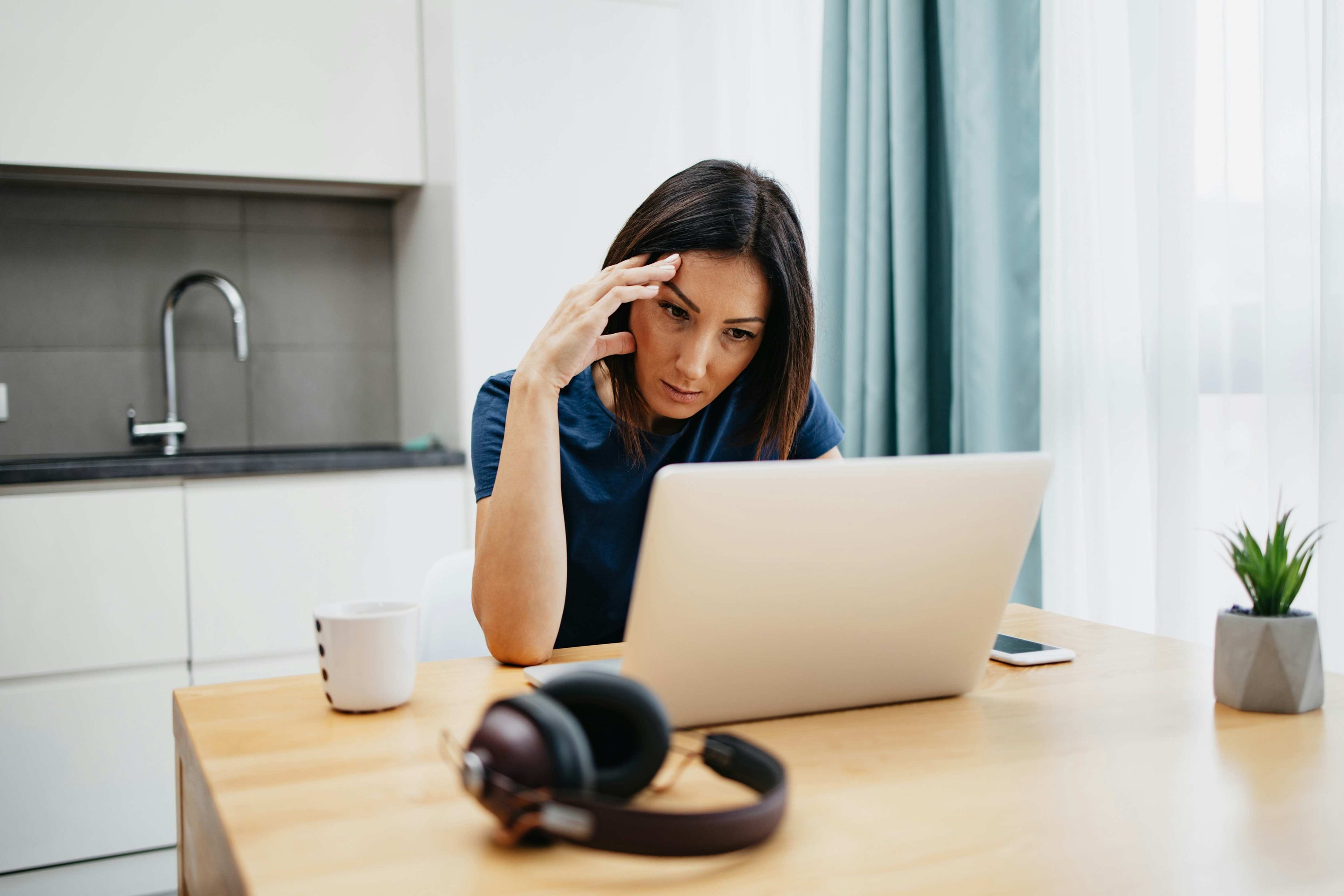 Focused woman researching Vitamin B12 deficiency symptoms online, reflecting EcoSelect’s commitment to health education and wellness.